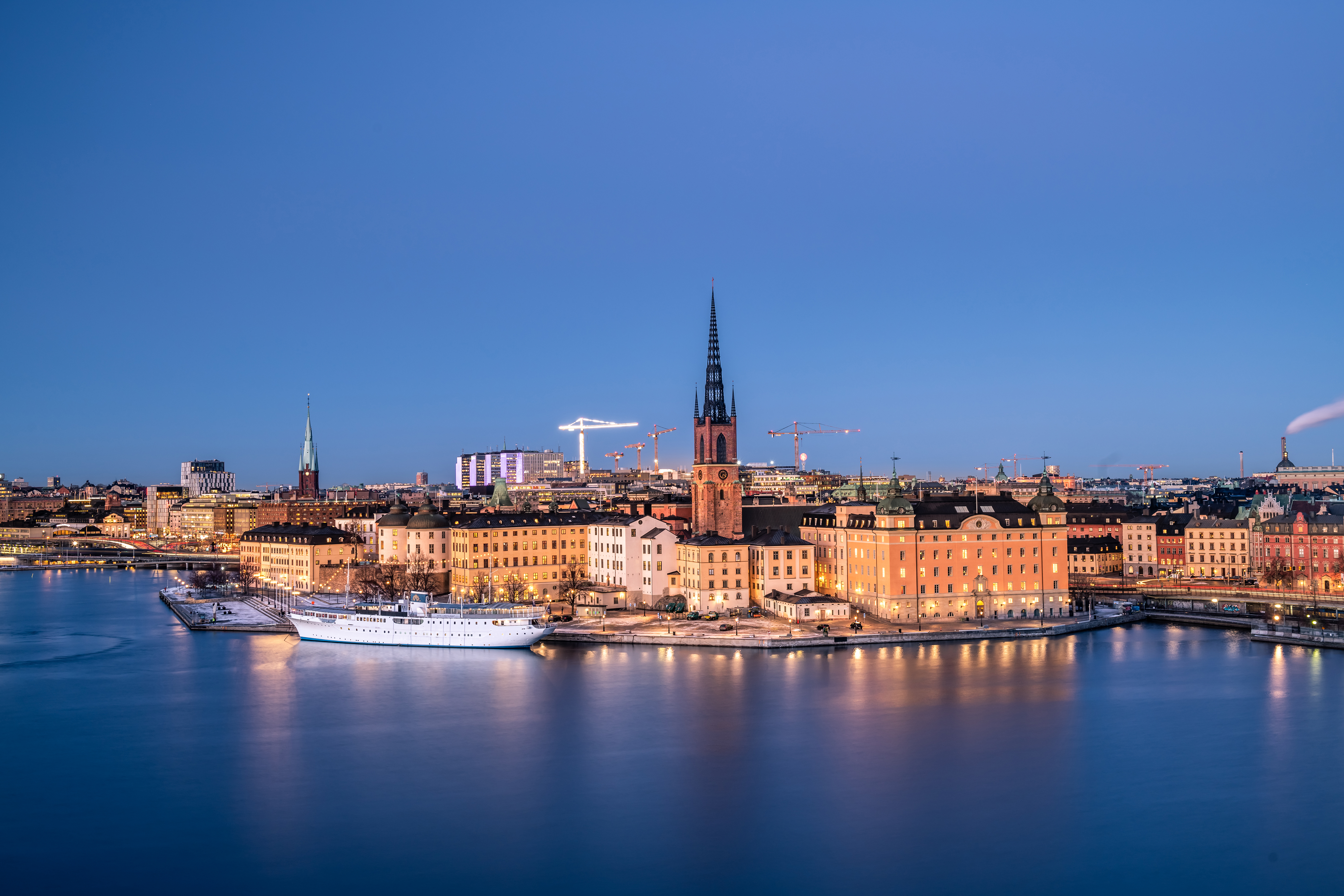 Stockholm Old Town waterfront at twilight with historic buildings and Riddarholmen Church spire